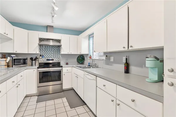 a kitchen with cabinets appliances a sink and a window