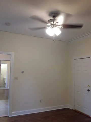 a view of an empty room with wooden floor