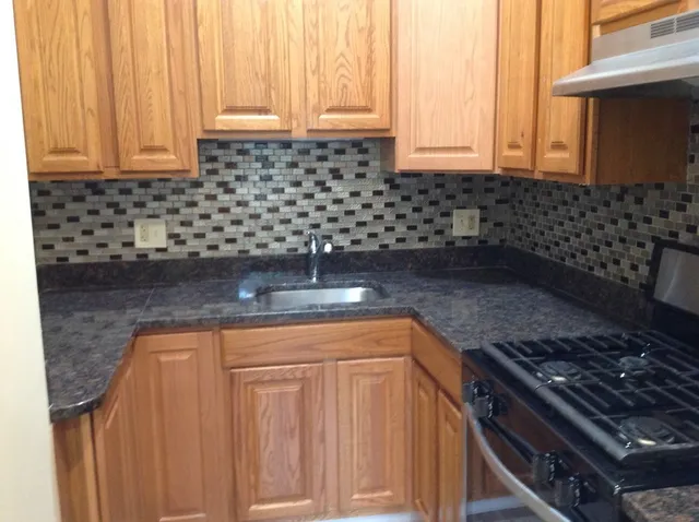 a kitchen with granite countertop a sink stainless steel appliances and cabinets