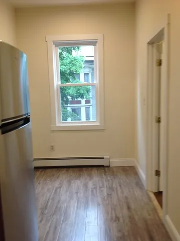 an empty room with wooden floor and a window
