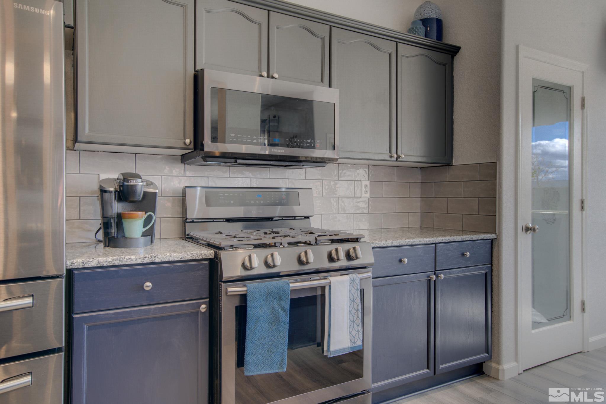 1625 Canyonlands Way Reno, NV 89521 - Photo 13 of 31 a kitchen with stainless steel appliances granite countertop a stove and a microwave