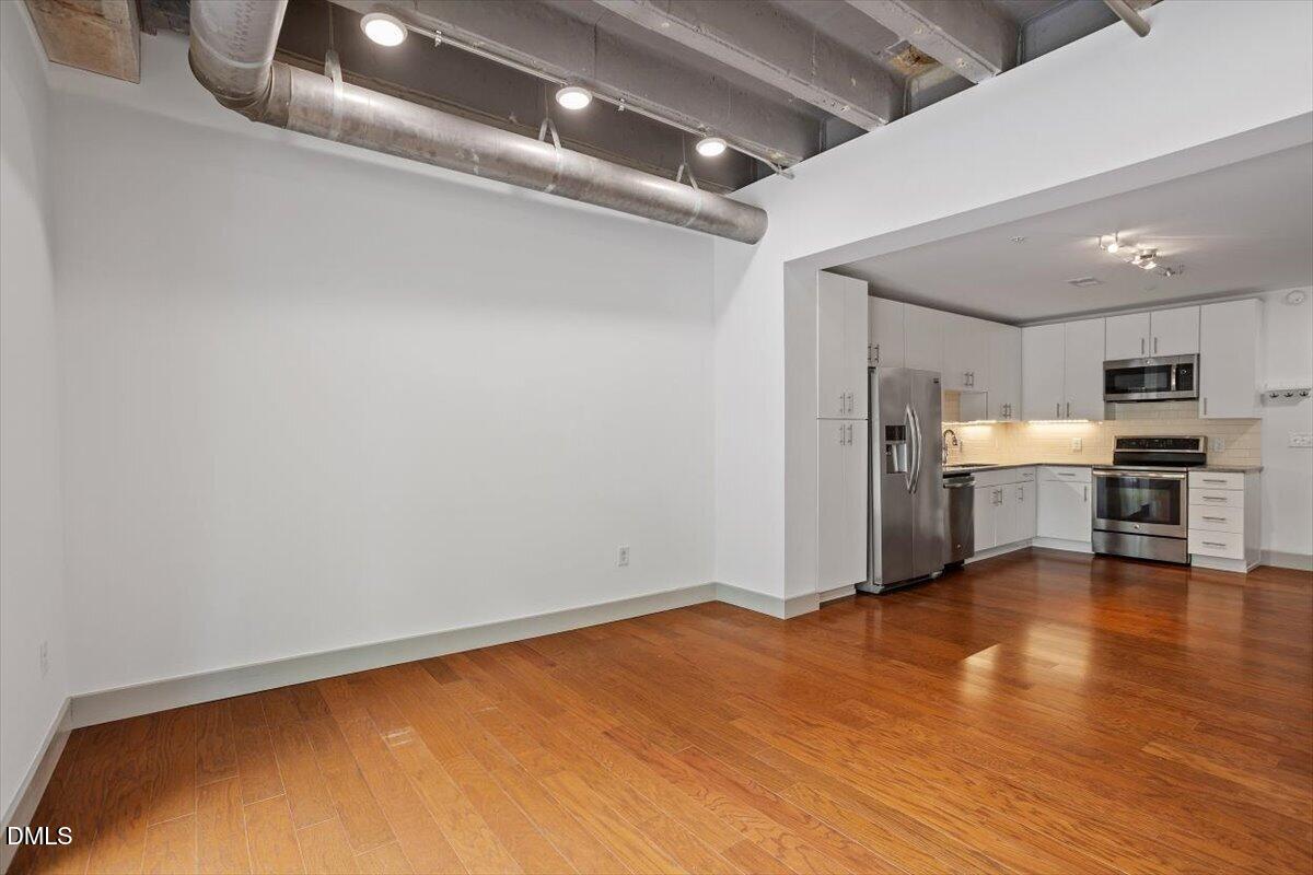 1300 St Marys Street, Unit 207 Raleigh, NC 27605 - Photo 6 of 31 a view of a livingroom with wooden floor and a ceiling fan