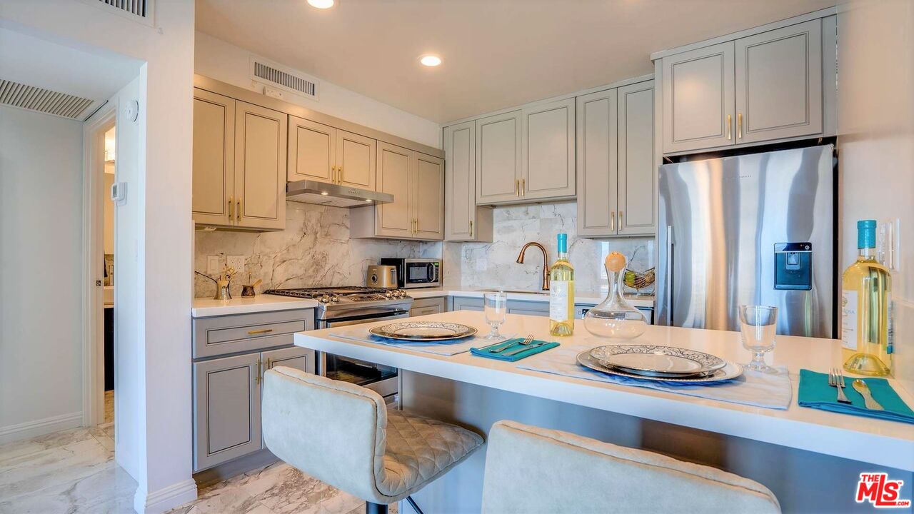 a kitchen with white cabinets stove and refrigerator