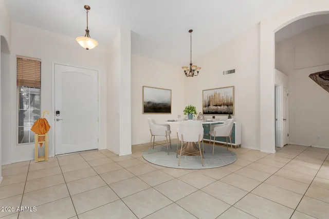 a view of an empty room and chandelier fan