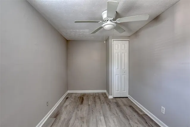 a view of a room with wooden floor and fan