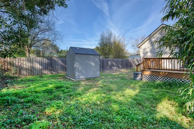a front view of a house with garden and a wooden fence