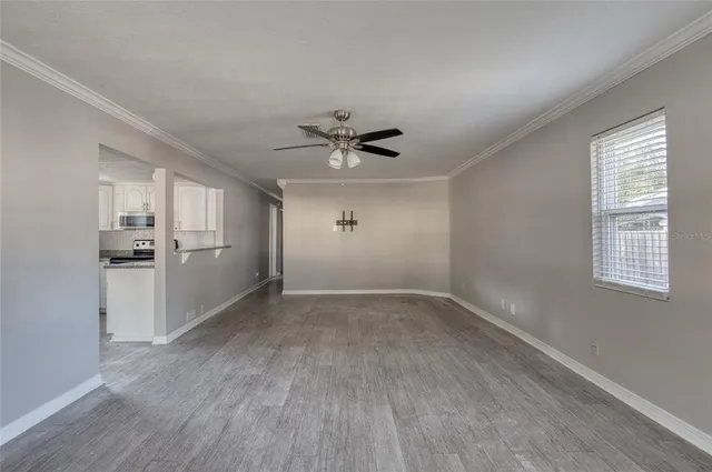 wooden floor in an empty room with a kitchen