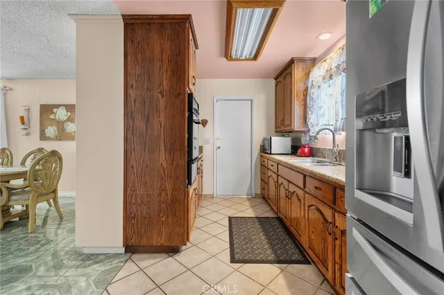 a bathroom with granite countertop a sink and a refrigerator