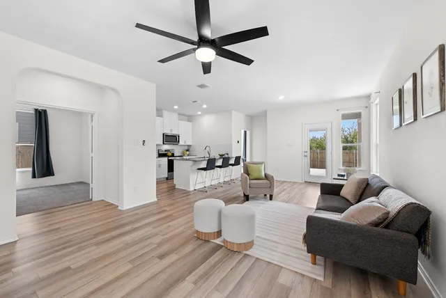 a living room with furniture and a view of kitchen