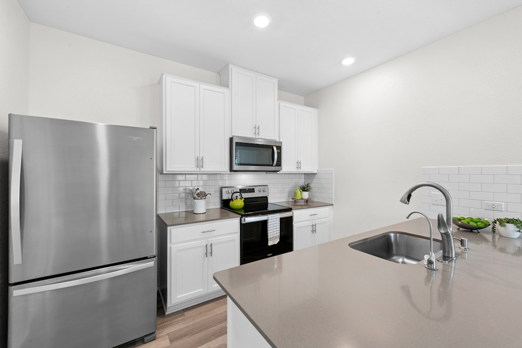 438 Thunder Valley Trail Georgetown, TX 78626 - Photo 3 of 21 a kitchen with a refrigerator sink and white cabinets