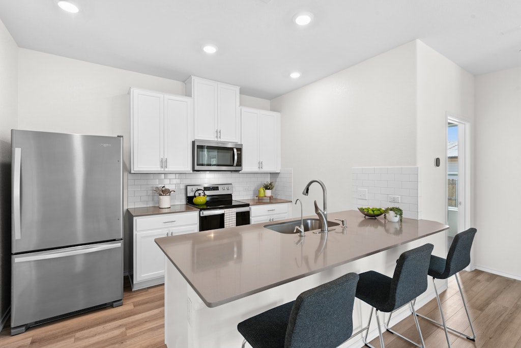 438 Thunder Valley Trail Georgetown, TX 78626 - Photo 5 of 21 a kitchen with stainless steel appliances a refrigerator a sink a stove a table and chairs