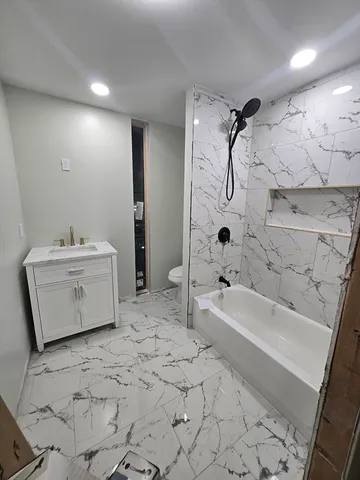 a large white kitchen with wooden floors and stainless steel appliances