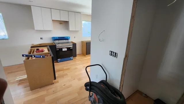 a kitchen with stainless steel appliances granite countertop a stove top oven a sink a refrigerator and white cabinets