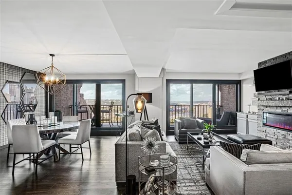a living room with furniture a flat screen tv and a large window