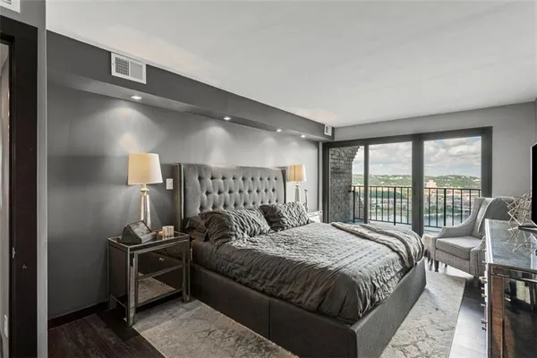 a bedroom with a bed and large windows