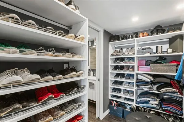 a view of walk in closet with clothes and shoes