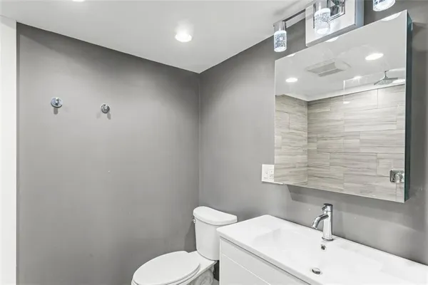 a bathroom with a toilet a sink and mirror