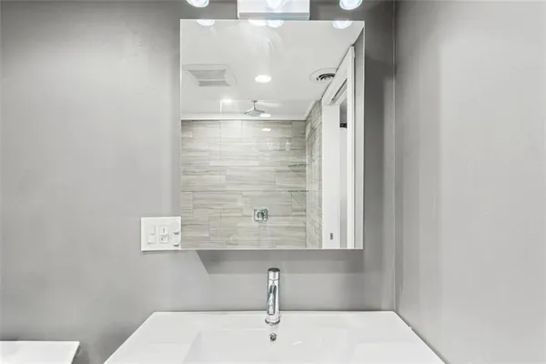 a bathroom with a sink a mirror and shower