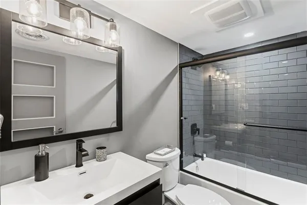 a bathroom with a sink a toilet and shower