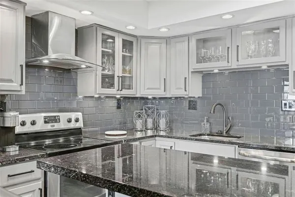 a kitchen with stainless steel appliances granite countertop a sink stove and cabinets