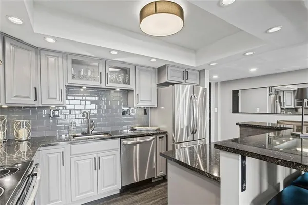a kitchen with stainless steel appliances granite countertop a sink stove and refrigerator