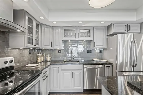 a kitchen with granite countertop a stove sink and cabinets