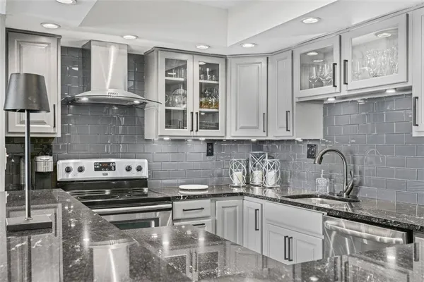 a kitchen with stainless steel appliances granite countertop a stove a sink and cabinets
