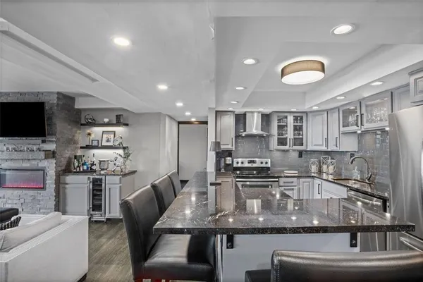 a kitchen with stainless steel appliances granite countertop a sink refrigerator and cabinets
