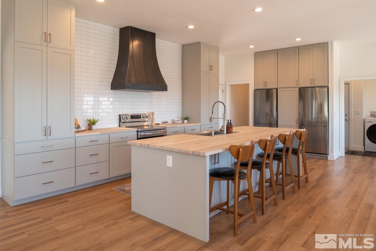 4600 Tybo Road Reno, NV 89521 - Photo 6 of 40 a kitchen with stainless steel appliances a sink stove and wooden floor