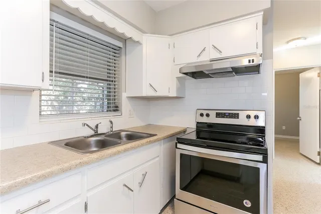 a kitchen with a sink stove and cabinets
