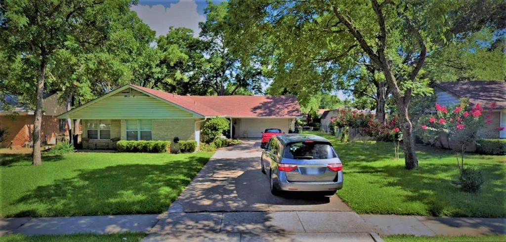 Ranch-style home featuring concrete driveway, a front lawn, and brick siding