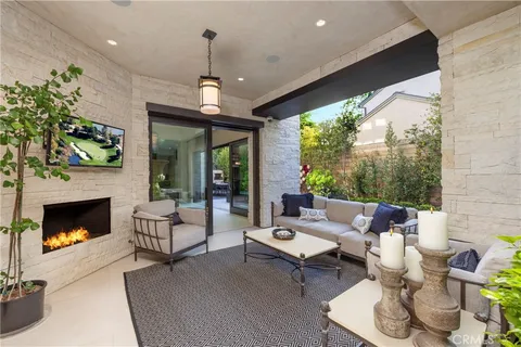 a living room with patio fireplace furniture and a fireplace