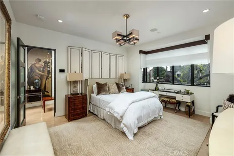 a spacious bedroom with a bed and a chandelier