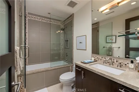 a bathroom with a bathtub shower sink mirror and toilet