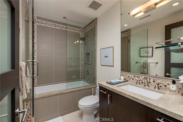 a bathroom with a bathtub shower sink mirror and toilet