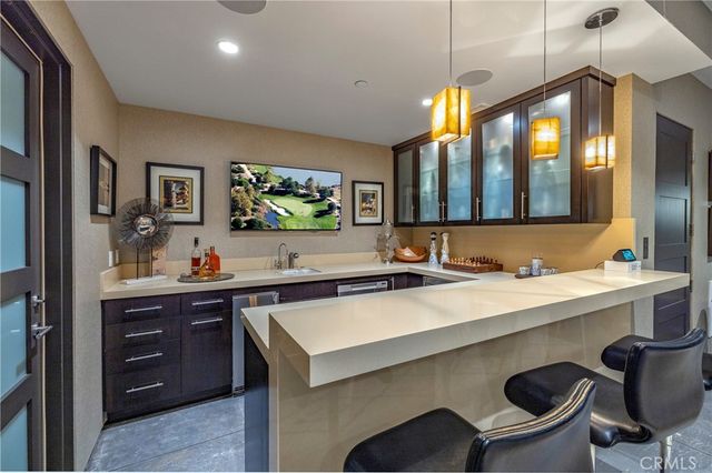 a kitchen with a sink a counter and chairs