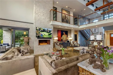 a living room with fireplace furniture and a potted plant