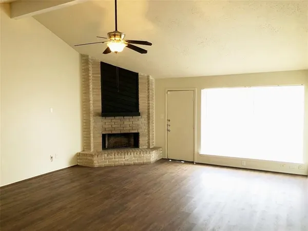 a view of a livingroom with a fireplace and wooden floor