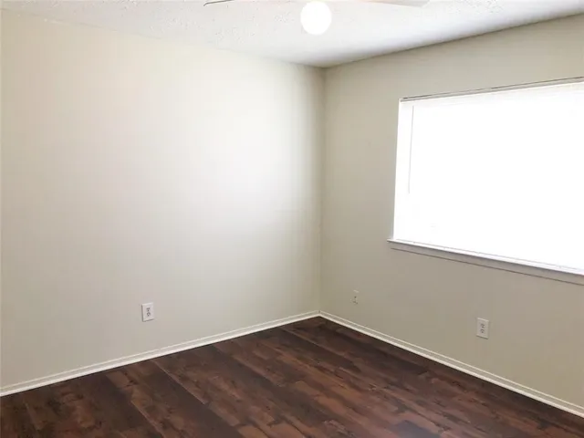 a view of a small space with wooden floor and a window