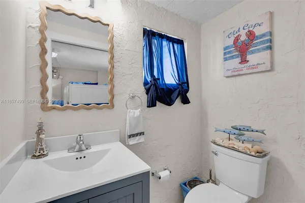 a large kitchen with stainless steel appliances kitchen island granite countertop a stove a sink and white cabinets with wooden floor