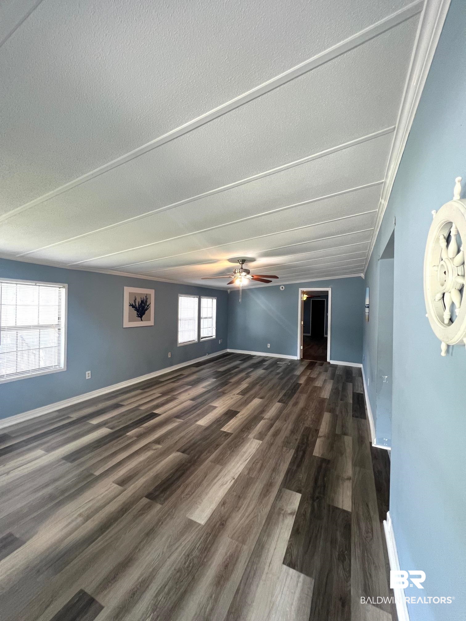 24994 Pompano Drive Elberta, AL 36530 - Photo 4 of 14 Spare room featuring dark wood-style flooring, a ceiling fan, and a textured ceiling