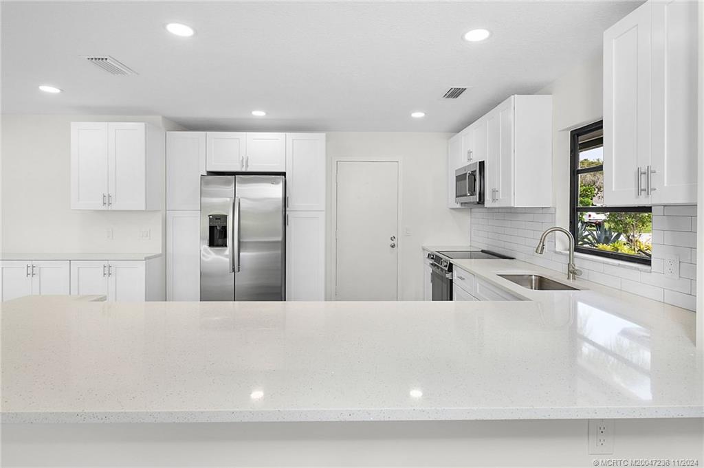 5635 Southeast Miles Grant Road Stuart, FL 34997 - Photo 17 of 73 a large kitchen with stainless steel appliances