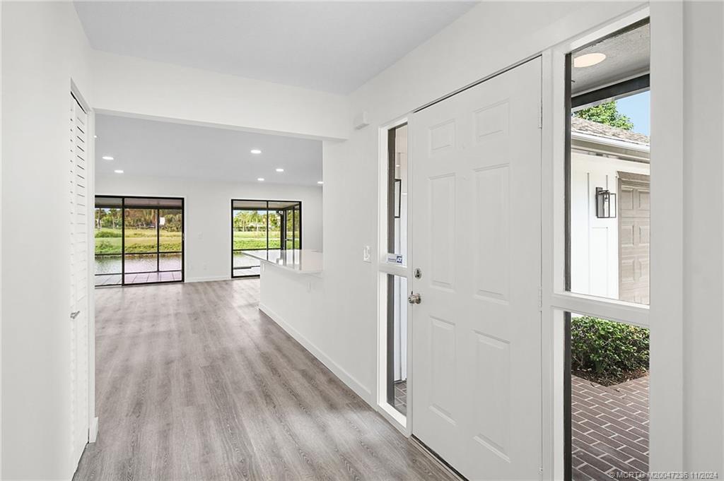 5635 Southeast Miles Grant Road Stuart, FL 34997 - Photo 21 of 73 a view of a hallway with wooden floor and a living room