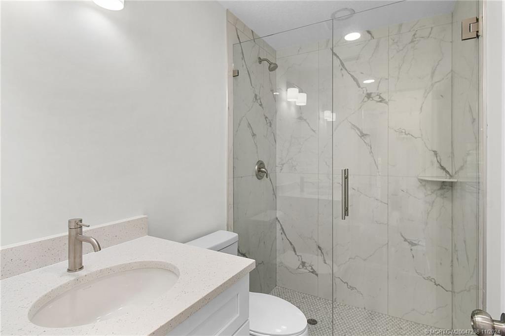 5635 Southeast Miles Grant Road Stuart, FL 34997 - Photo 23 of 73 a bathroom with a sink toilet and shower