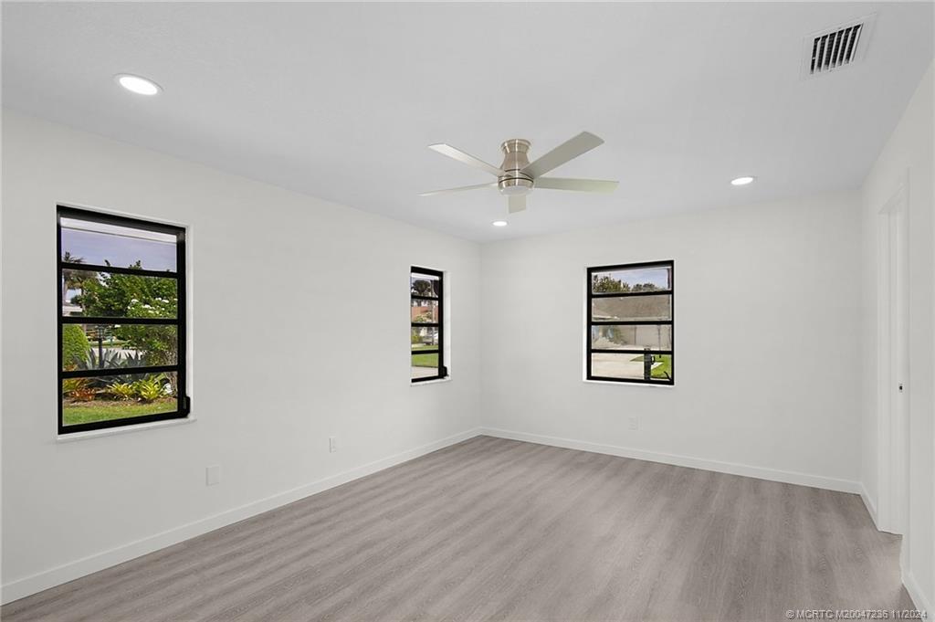 5635 Southeast Miles Grant Road Stuart, FL 34997 - Photo 31 of 73 a view of an empty room with a window and wooden floor