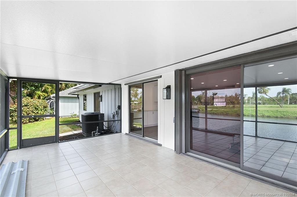 5635 Southeast Miles Grant Road Stuart, FL 34997 - Photo 43 of 73 a view of a porch with furniture and floor to ceiling window