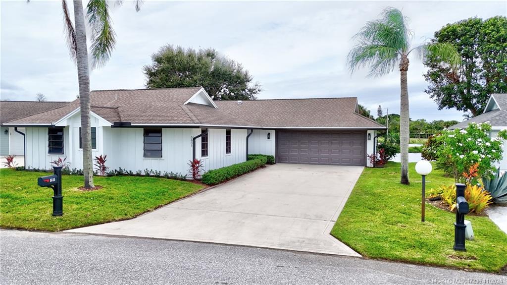 5635 Southeast Miles Grant Road Stuart, FL 34997 - Photo 73 of 73 a front view of a house with a yard and potted plants