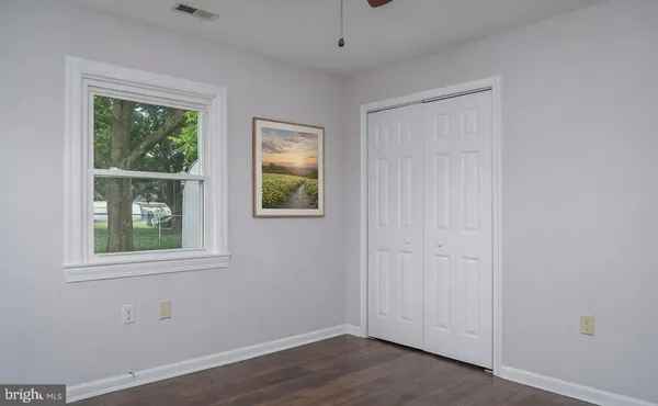an empty room with a window and wooden floor