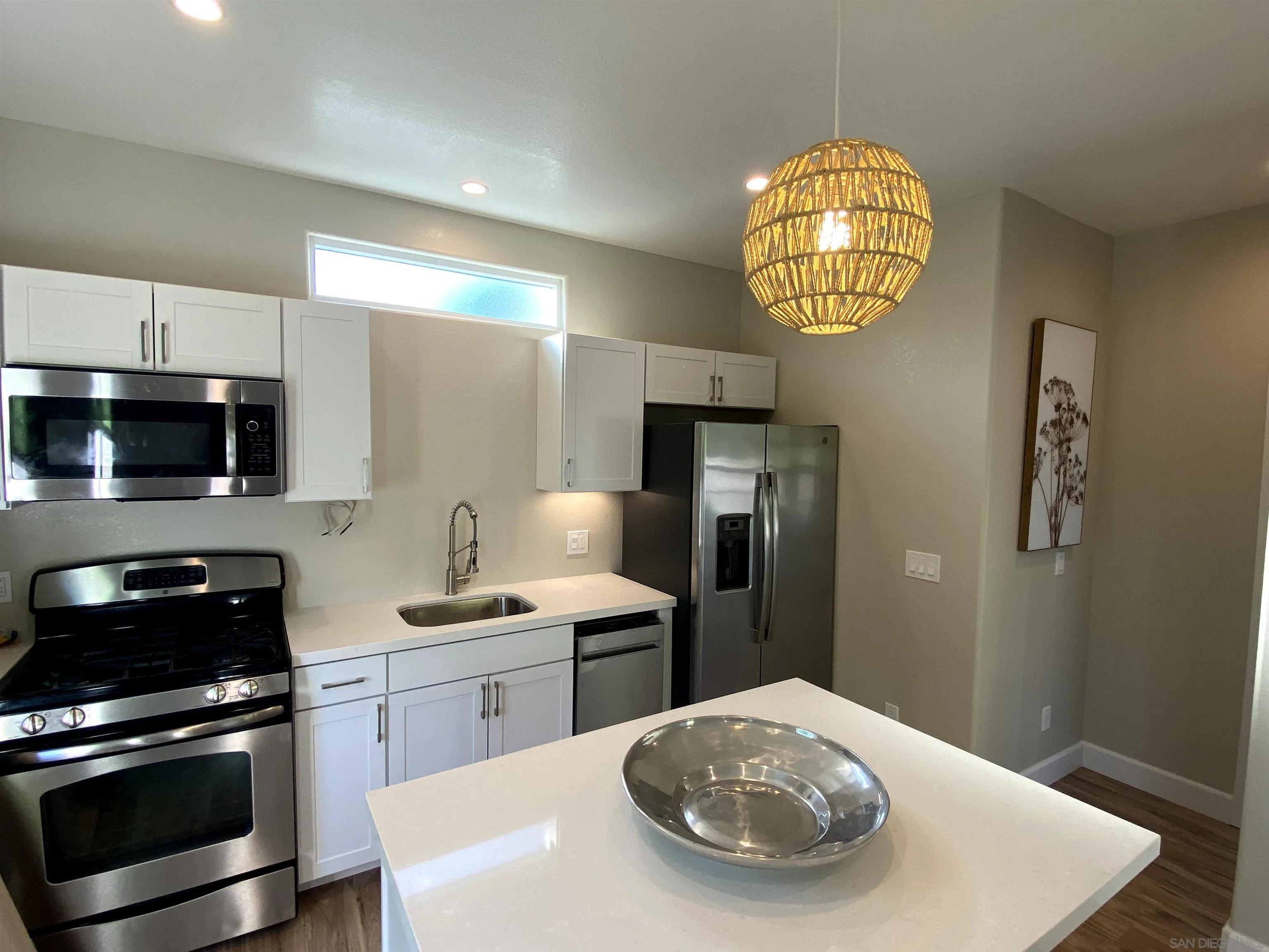 1774 Dove Lane Carlsbad, CA 92011 - Photo 7 of 25 a kitchen with stainless steel appliances a sink a stove and white cabinets