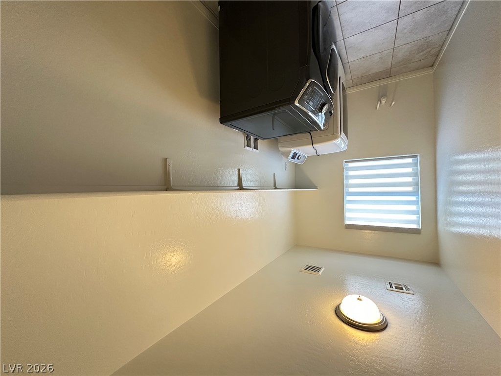 6784 Pivot Point Street Las Vegas, NV 89148 - Photo 25 of 27 Functional laundry room equipped with contemporary appliances and practical shelving.